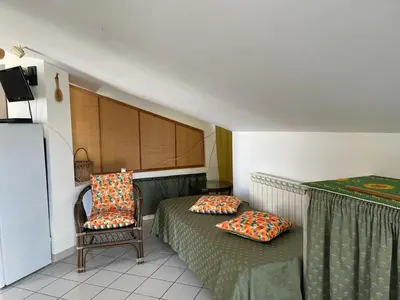 a small room with two beds and a chair at Villa Tocco vicino al mare in Balestrate