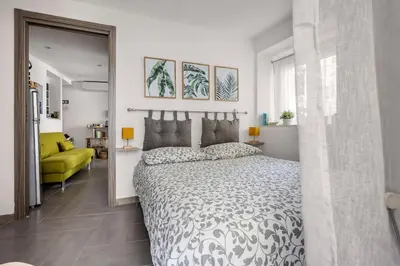 a bedroom with a large bed and a yellow couch at Capo Sweet Home in Palermo
