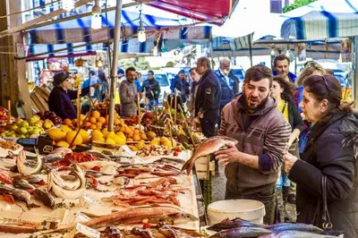 a man and woman standing at a market with seafood at Capo Sweet Home in Palermo