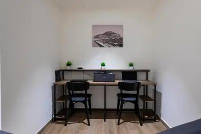 a desk with three chairs and a computer on it at Marina Rooms - Guesthouse in Palermo