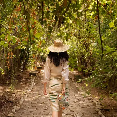 a woman walking down a path with a hat at Casa Panoramica in Terrasini