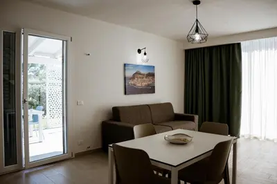 a living room with a table and a couch at Residence Salinelle Beach Villa Panarea in Lascari