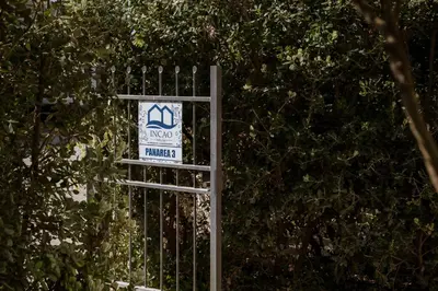 a sign on a gate in front of trees at Residence Salinelle Beach Villa Panarea in Lascari