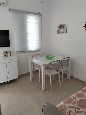 a white dining room table with chairs and a television at Villetta al villaggio 101 pini in Campofelice di Roccella