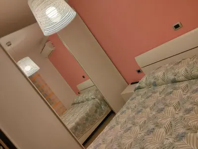a mirror in a bedroom with a bed at Villetta al villaggio 101 pini in Campofelice di Roccella