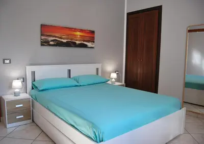 a bedroom with a bed with blue pillows at Casa Punta Barcarello, Sferracavallo fronte mare e tramonti da sogno, a due passi dalla splendida spiaggia di Mondello in Palermo