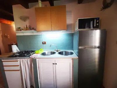 a small kitchen with a sink and a refrigerator at kappa's house a granni in Palermo