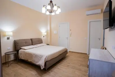 a bedroom with a bed and a flat screen tv at Tribunale Suite in Termini Imerese