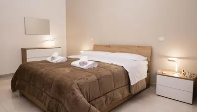 a bedroom with a large bed with towels on it at Leonetti in Carini