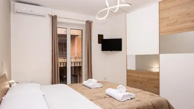 a white bedroom with two towels on a bed at Leonetti in Carini