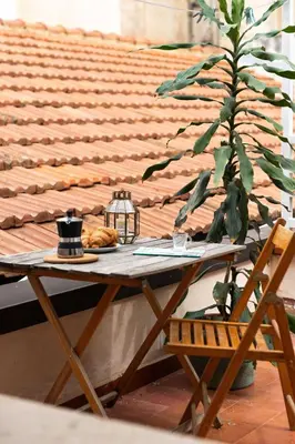a wooden table and a chair and a plant at Civico 61 in Palermo