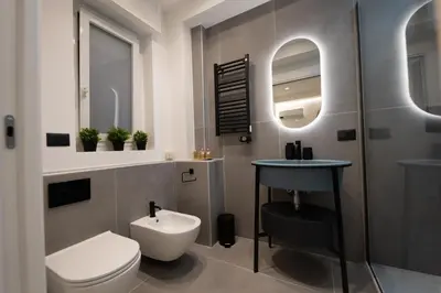 a bathroom with a toilet and a sink and mirror at Casa Chicotta- Libertà in Palermo