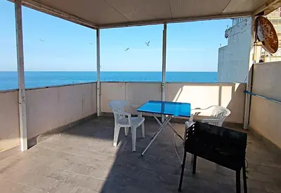 a balcony with a table and chairs and the ocean at Mare Blu in Palermo