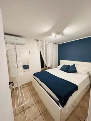 a bedroom with a bed with a blue wall at Blue Charm Exclusive Apartment in Palermo