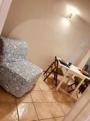 a living room with a chair and a table at Blue Charm Exclusive Apartment in Palermo