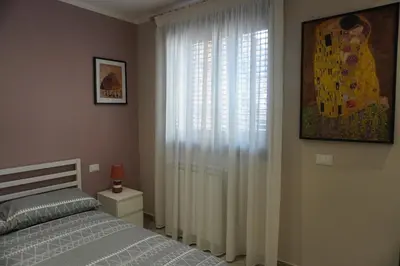 a bedroom with a bed and a window with curtains at Maria's Home in Altavilla Milicia