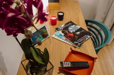 a table with a book and a vase with a plant at HrD Luxury Rooms in Palermo