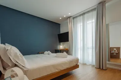 a bedroom with a large bed and a blue wall at HrD Luxury Rooms in Palermo