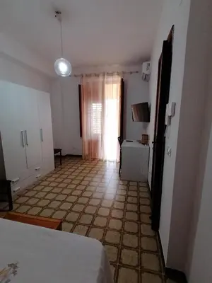 a bedroom with a bed and a room with a window at Terrazza al mare in Santa Flavia