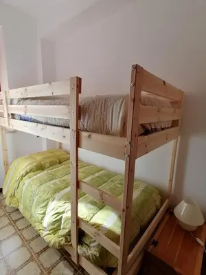 two bunk beds in a room with green sheets at Terrazza al mare in Santa Flavia