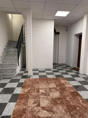 an empty room with a checkered floor and stairs at A Casa di Frank in Palermo