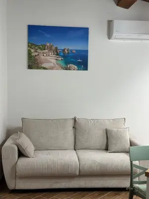 a living room with a couch against a white wall at A Casa di Frank in Palermo