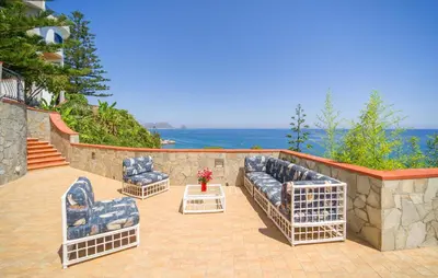 a patio with two couches and the ocean at Nice Home In Altavilla Milicia in Altavilla Milicia