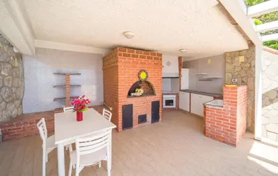 a kitchen with a table and a brick fireplace at Nice Home In Altavilla Milicia in Altavilla Milicia