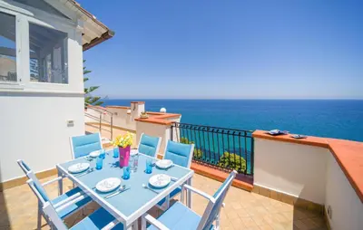 a table and chairs on a balcony with the ocean at Nice Home In Altavilla Milicia in Altavilla Milicia