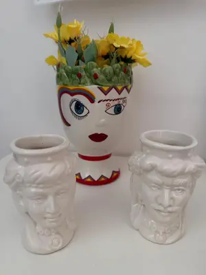 a white vase with a face and a flower arrangement at Appartamento Nonna Rosalba in Palermo