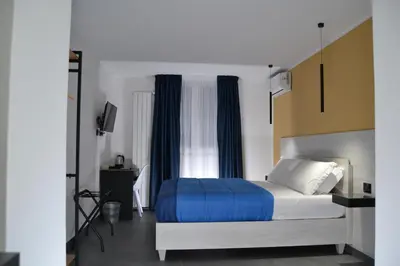 a bedroom with a bed with blue sheets and a window at Dimora Garibaldi in Palermo