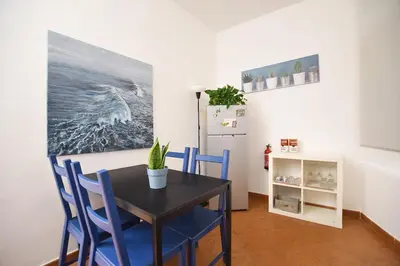 a dining room with a table and chairs and a refrigerator at iFlat Casa Riccino in Palermo