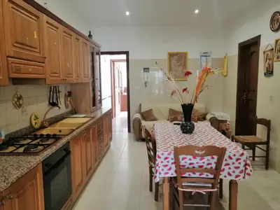 a kitchen with a table with a vase of flowers on it at Albachiara in Balestrate