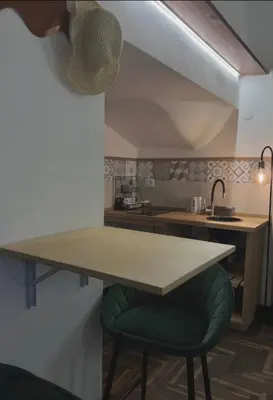 a kitchen with a table and a green stool at Ausa 20 - Tra Storia e Mare in Palermo