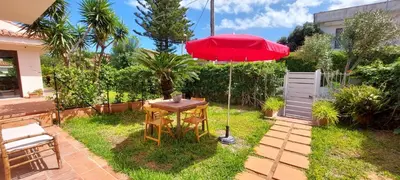a table with a red umbrella in a yard at Giunone Garden in Palermo