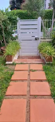 a walkway with a white gate in a yard at Giunone Garden in Palermo