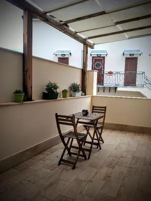 a table and chairs on the balcony of a house at Guest House Lo specchio sul mare in Santa Flavia
