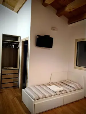 a bedroom with a bed and a tv on the wall at Guest House Lo specchio sul mare in Santa Flavia