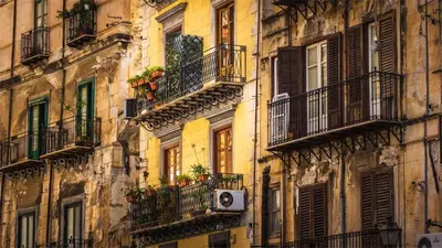 an old building with balconies and windows and a speaker at Suitt Drims 6 in Palermo