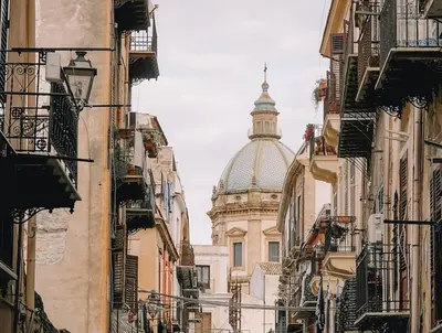 a view of a cathedral from between buildings at Suitt Drims 6 in Palermo