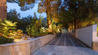 a walkway in a park with trees and plants at Casale Buccellato 14 by Massimo Villas in Castellammare del Golfo