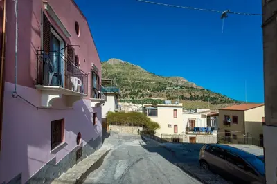 a street in a town with a mountain in the background at Casa Vacanze Cappuccini in Castellammare del Golfo