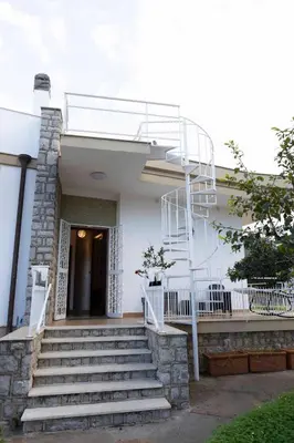 a white house with stairs and a fire escape at Sicily Wonders, 2 minute walk to the beach in Villagrazia