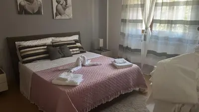 a bedroom with a pink bed with towels on it at Sicily Wonders, 2 minute walk to the beach in Villagrazia