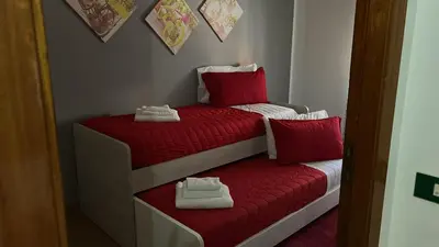 two beds with red sheets and white shoes on them at Sicily Wonders, 2 minute walk to the beach in Villagrazia
