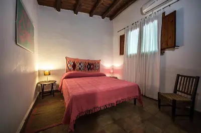 a bedroom with a bed with a red blanket and a window at Casa Conigli con piscina condivisa in Terrasini