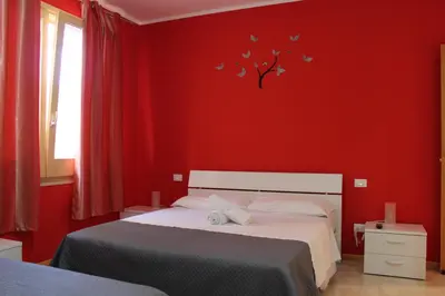 a red bedroom with a bed and a tree with butterflies at Casa Chiarenza in Castellammare del Golfo