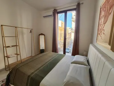 a bedroom with a large bed and a window at Palazzo Orangea 1 piano in Bagheria