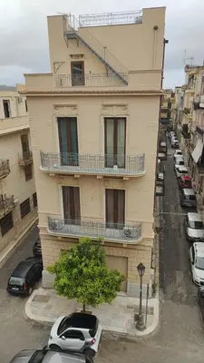 a building with cars parked in a parking lot at Palazzo Orangea 1 piano in Bagheria