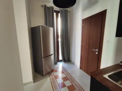 a kitchen with a stainless steel refrigerator and a door at Palazzo Orangea 1 piano in Bagheria